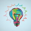 a light bulb filled with vibrant splashes of paint in shades of blue, green, yellow, and red. 